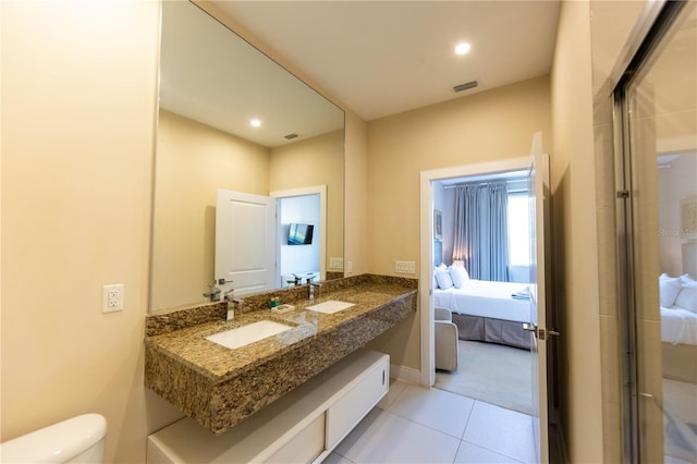 bathroom featuring an enclosed shower, tile floors, toilet, and dual vanity