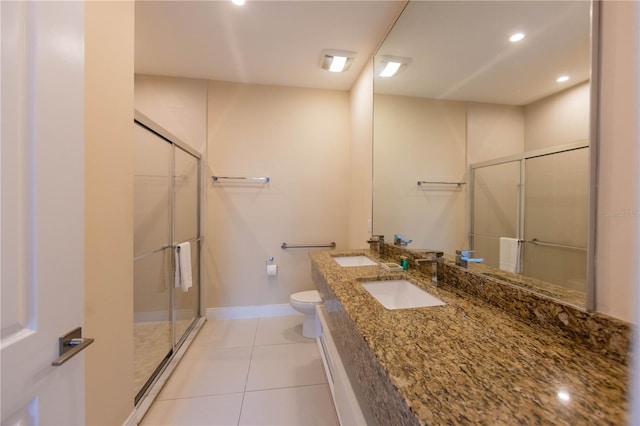 bathroom featuring an enclosed shower, large vanity, tile flooring, dual sinks, and toilet