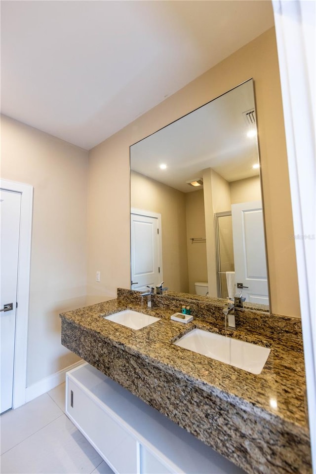 bathroom featuring tile flooring, toilet, and double sink vanity