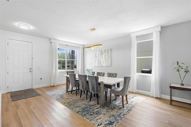 dining area featuring light hardwood / wood-style floors and a textured ceiling