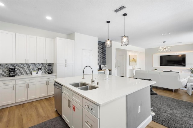 kitchen with light hardwood / wood-style flooring, white cabinets, and sink