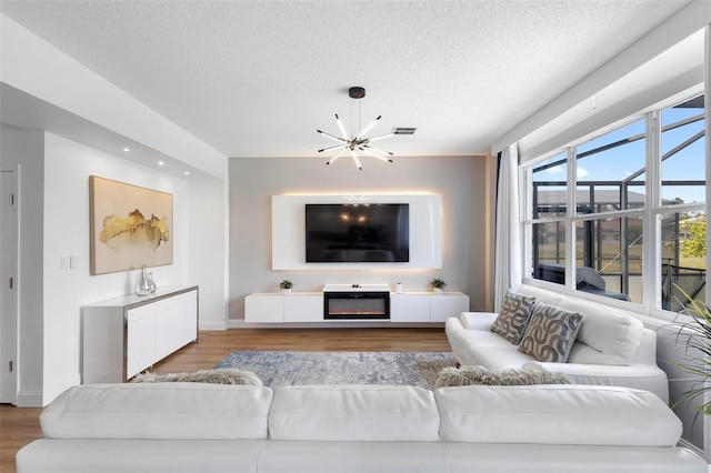 living room with a textured ceiling, an inviting chandelier, and hardwood / wood-style flooring