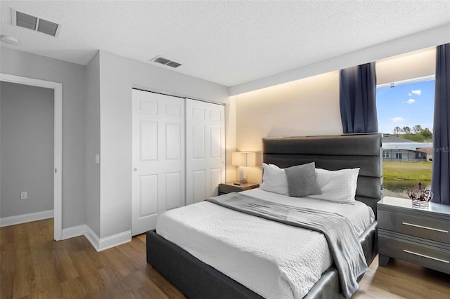 bedroom featuring a closet, a textured ceiling, and hardwood / wood-style floors