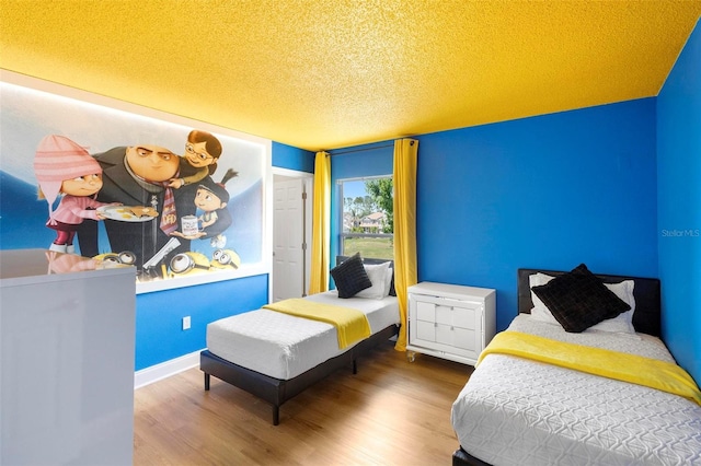 bedroom featuring wood-type flooring and a textured ceiling