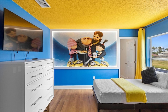 bedroom featuring a textured ceiling and hardwood / wood-style floors