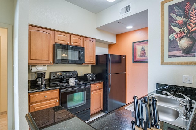 kitchen with dark stone countertops, black appliances, and sink