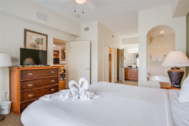 bedroom featuring light tile flooring, ensuite bathroom, and ceiling fan