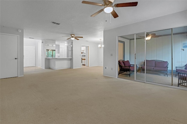 unfurnished living room with light carpet, a textured ceiling, and ceiling fan