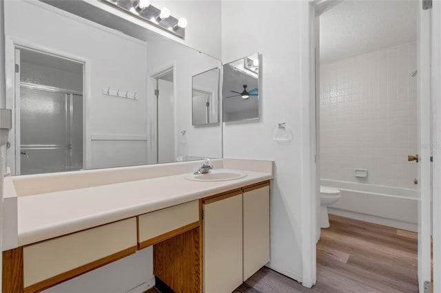 full bathroom with ceiling fan, hardwood / wood-style flooring, toilet, vanity, and shower / bath combination