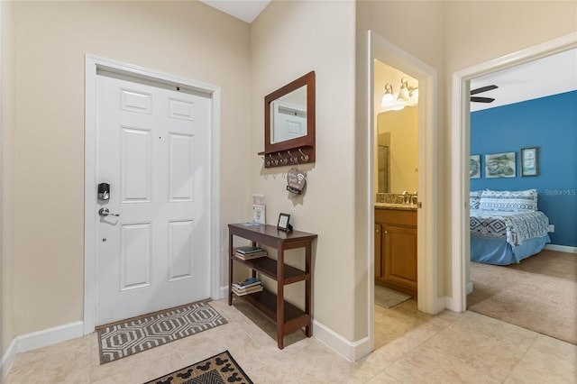 carpeted entryway featuring ceiling fan and sink