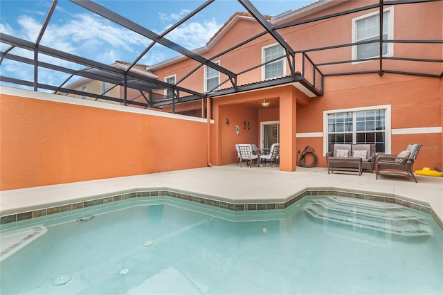 view of pool with glass enclosure, outdoor lounge area, and a patio area