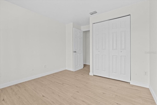 unfurnished bedroom with a closet and light wood-type flooring