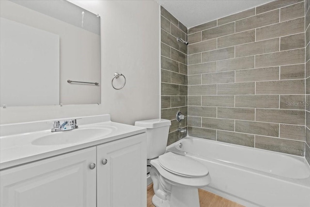 full bathroom featuring vanity, toilet, tiled shower / bath combo, and hardwood / wood-style floors