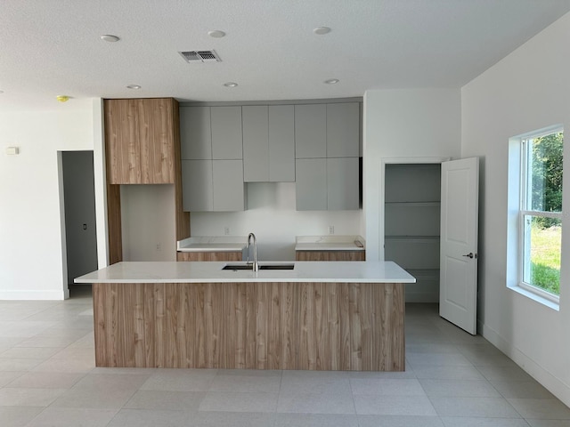 kitchen featuring light tile patterned flooring, a wealth of natural light, and sink