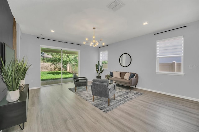 living room featuring wood-type flooring and an inviting chandelier