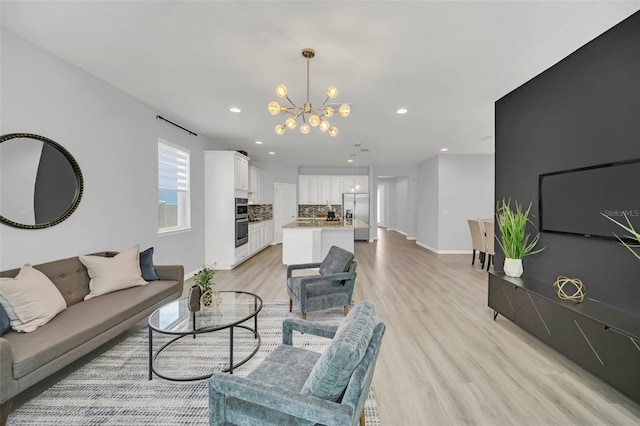 living room with light wood-type flooring and a notable chandelier