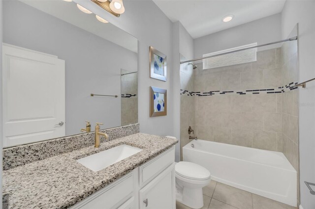 full bathroom featuring tile patterned floors, toilet, tiled shower / bath combo, and vanity