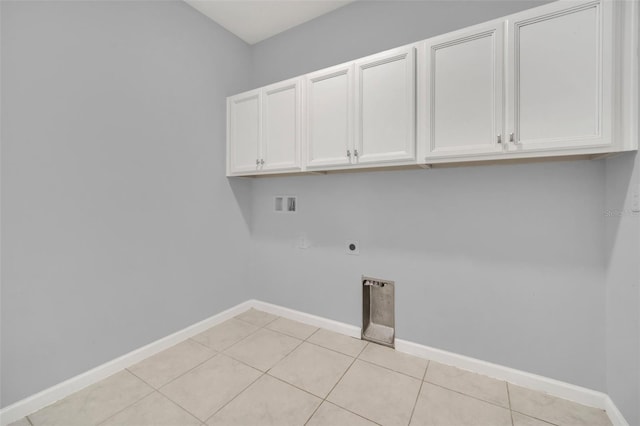 clothes washing area with washer hookup, light tile patterned floors, hookup for an electric dryer, and cabinets