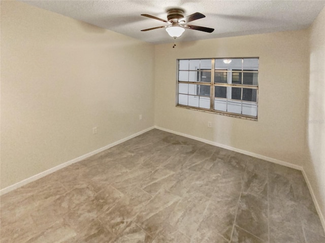 unfurnished room with ceiling fan and a textured ceiling