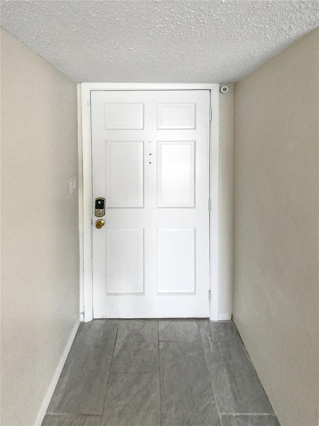 interior space featuring dark tile floors and a textured ceiling