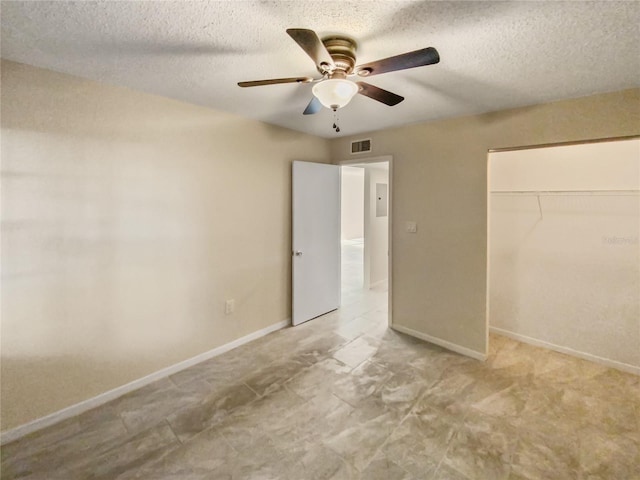 tiled empty room with a textured ceiling and ceiling fan