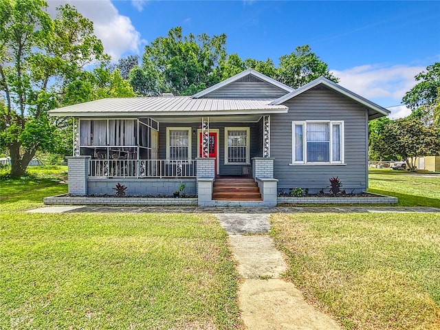 bungalow with covered porch and a front yard