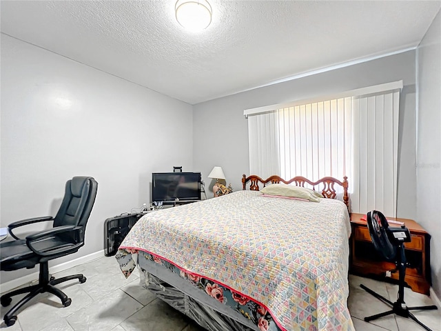 tiled bedroom featuring a textured ceiling