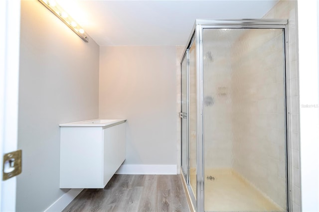 bathroom with vanity, hardwood / wood-style floors, and a shower with shower door