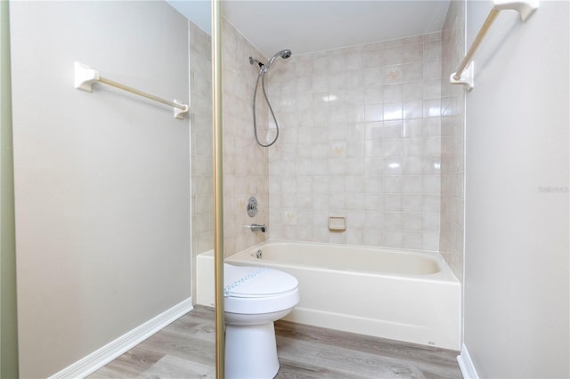 bathroom with tiled shower / bath, toilet, and wood-type flooring