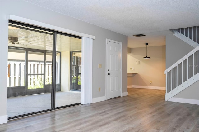 doorway featuring a textured ceiling, hardwood / wood-style floors, and ceiling fan