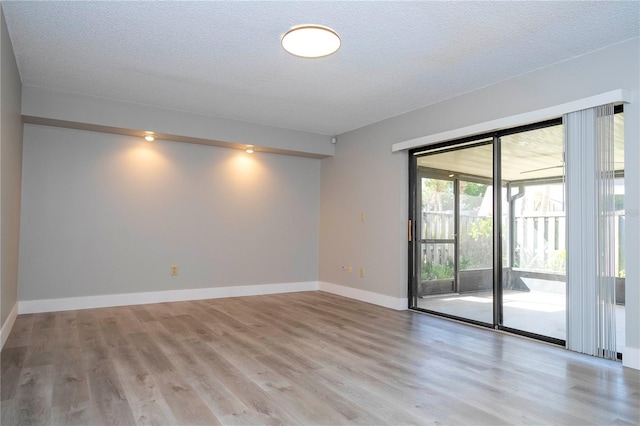 spare room with wood-type flooring and a textured ceiling