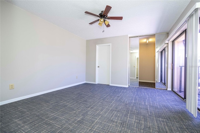 unfurnished bedroom featuring dark carpet, ceiling fan, and a textured ceiling