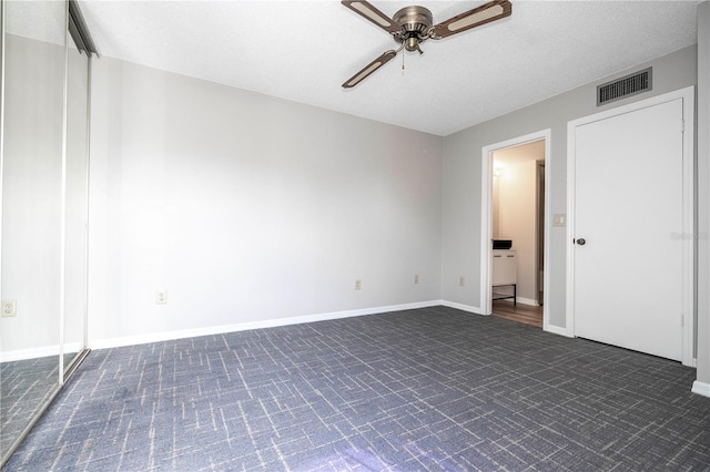 unfurnished bedroom with ceiling fan and a textured ceiling