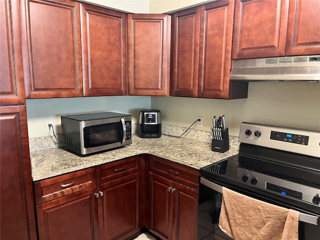 kitchen featuring stainless steel appliances, tile floors, and light stone counters