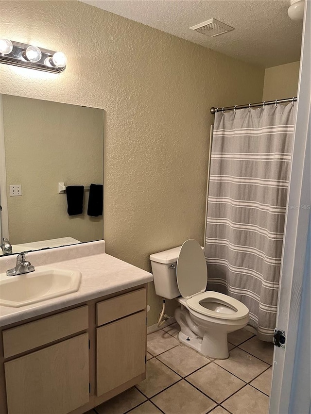 bathroom featuring vanity, a textured ceiling, tile floors, and toilet