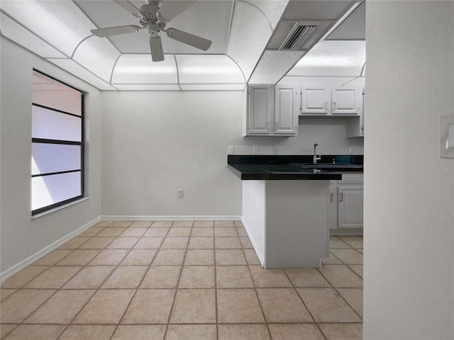 kitchen featuring light tile floors, white cabinetry, ceiling fan, and sink