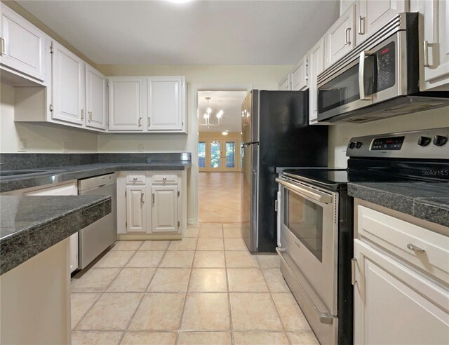 kitchen featuring white cabinets, an inviting chandelier, stainless steel appliances, and light tile patterned flooring