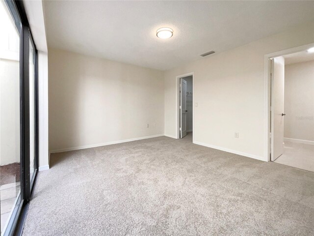 unfurnished bedroom with a textured ceiling and light colored carpet