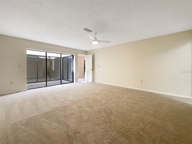 carpeted spare room featuring a textured ceiling and ceiling fan