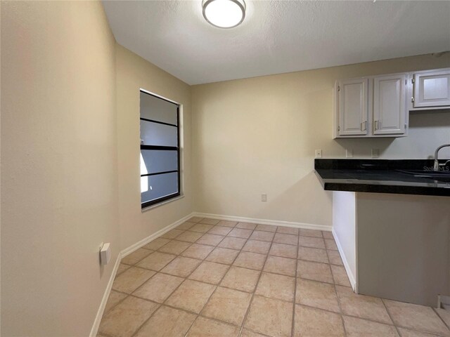 kitchen featuring white cabinets, sink, and a textured ceiling