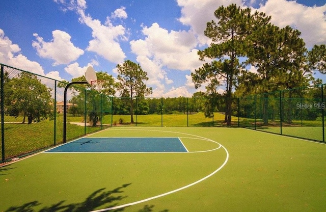 view of sport court featuring community basketball court, fence, and a lawn