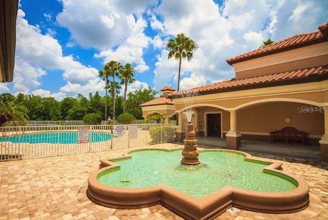 community pool featuring a patio area and fence