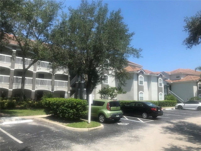 view of building exterior with uncovered parking and a residential view