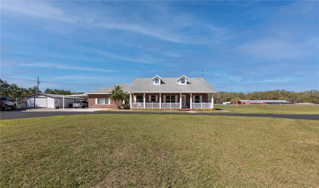 view of front of home featuring a front lawn, covered porch, and a garage