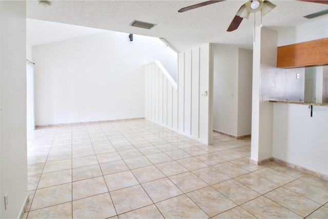 unfurnished room featuring ceiling fan, light tile patterned floors, a textured ceiling, and lofted ceiling