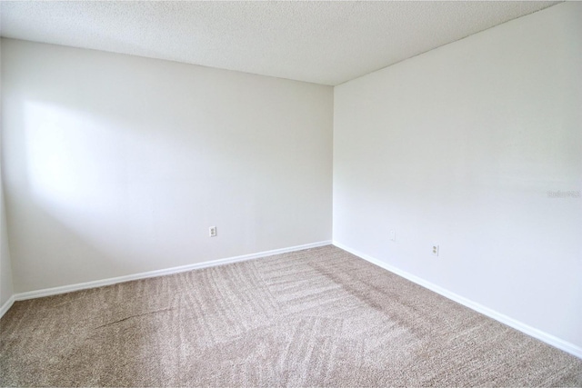 spare room with carpet and a textured ceiling