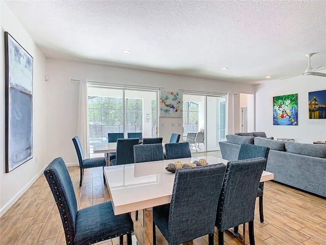 dining space featuring a textured ceiling, ceiling fan, light wood-type flooring, and french doors