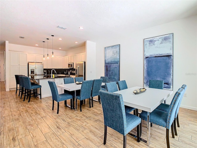 dining area with light hardwood / wood-style floors and sink