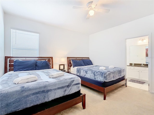 bedroom with light carpet, connected bathroom, and ceiling fan