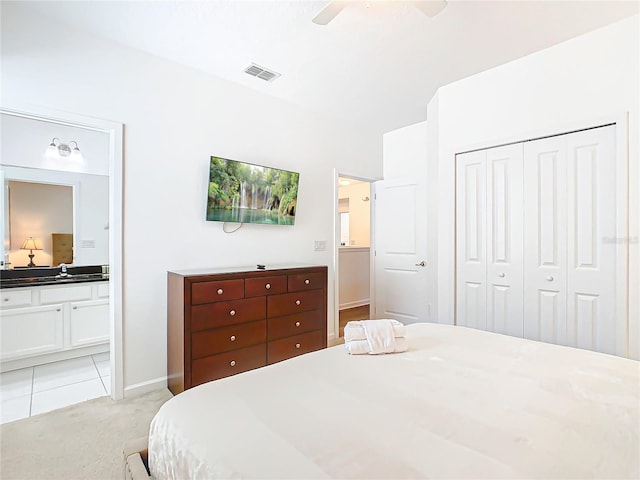 carpeted bedroom with connected bathroom, a closet, ceiling fan, and sink